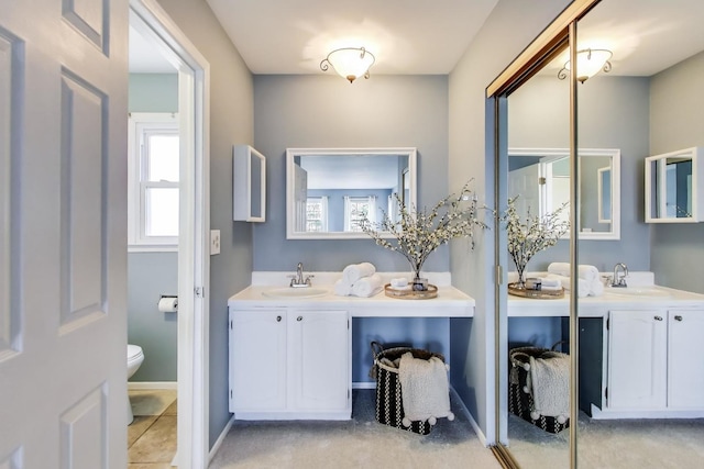 bathroom with baseboards, toilet, and vanity