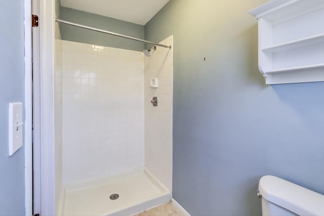 bathroom featuring a shower stall and toilet