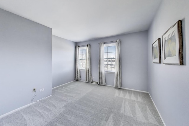 empty room featuring baseboards and carpet