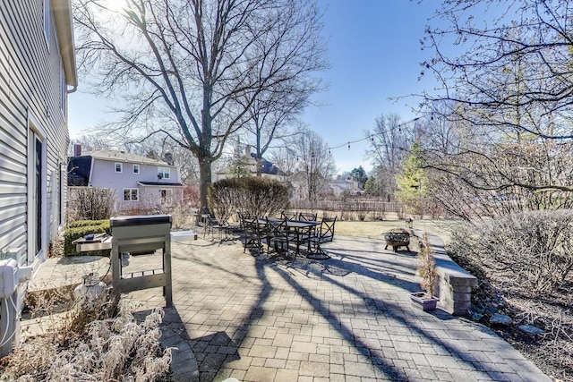 view of patio / terrace with outdoor dining area, a fire pit, and fence