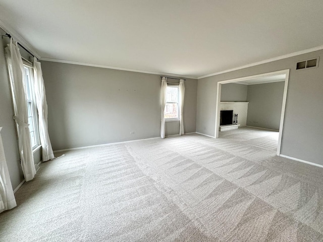 unfurnished living room featuring light carpet, a fireplace, and crown molding