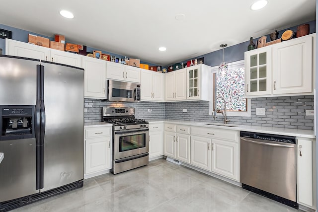 kitchen featuring stainless steel appliances, sink, white cabinets, and decorative backsplash