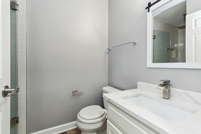 bathroom featuring vanity, an enclosed shower, and toilet