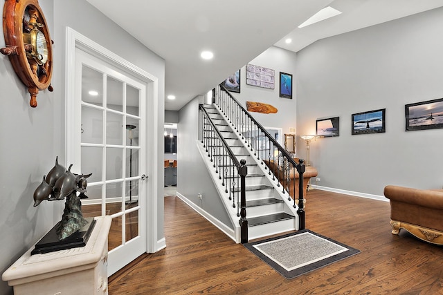 staircase with hardwood / wood-style flooring and a skylight