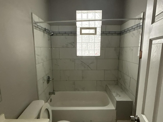 bathroom featuring toilet and tiled shower / bath combo