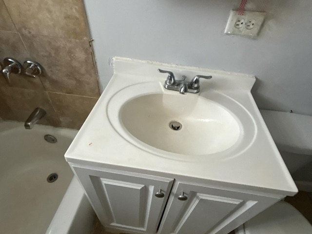 bathroom with a tub to relax in and vanity