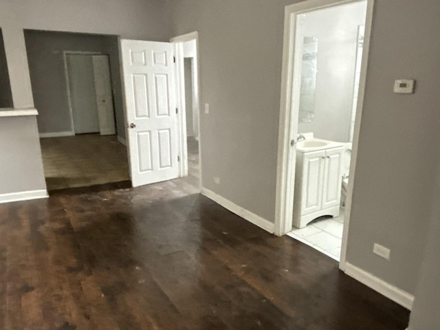 spare room with sink and dark wood-type flooring