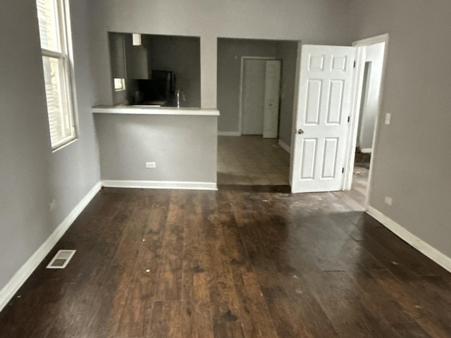 unfurnished living room featuring dark wood-type flooring