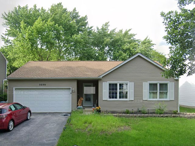 ranch-style house with a garage and a front yard