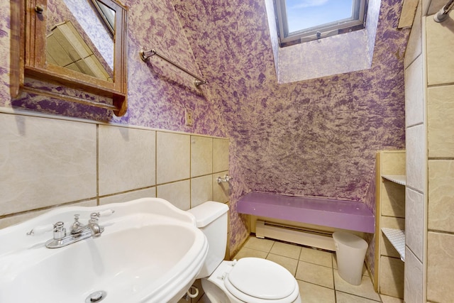 bathroom featuring baseboard heating, tile patterned floors, sink, and toilet