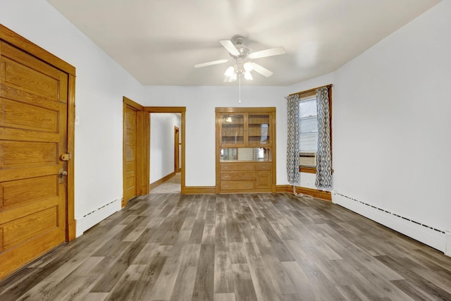 unfurnished living room with a baseboard heating unit, ceiling fan, and hardwood / wood-style floors