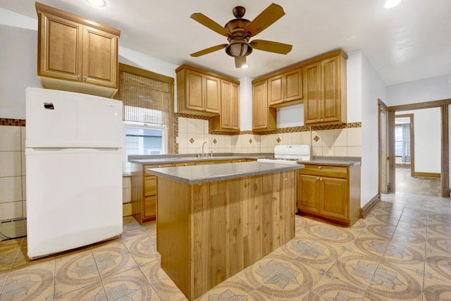 kitchen featuring ceiling fan, a kitchen island, sink, light tile patterned floors, and white refrigerator