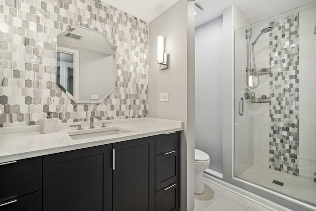 bathroom with tile patterned floors, toilet, vanity, and an enclosed shower