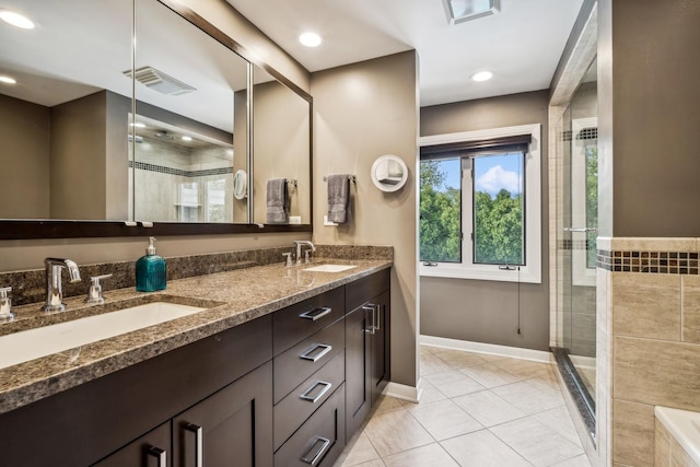 bathroom featuring vanity, tile patterned flooring, and a shower with door