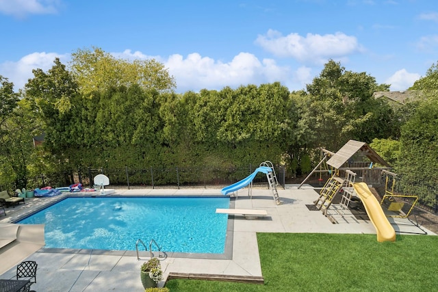 view of pool with a playground, a diving board, a lawn, and a water slide