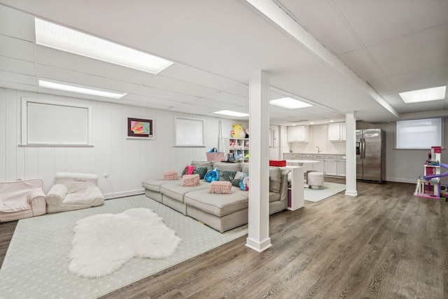 living room featuring a drop ceiling and dark hardwood / wood-style flooring