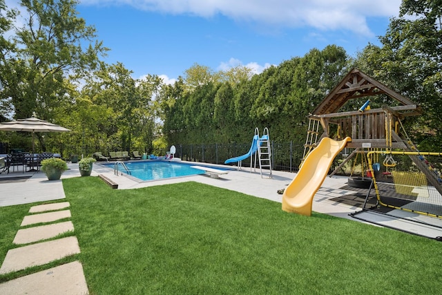 view of swimming pool featuring a playground, a patio area, a lawn, and a water slide