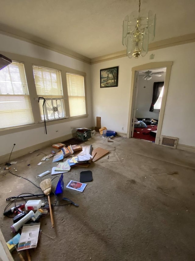 miscellaneous room with plenty of natural light, crown molding, and a chandelier