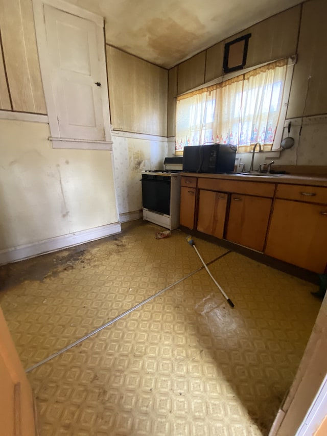 kitchen featuring white range with gas stovetop and sink