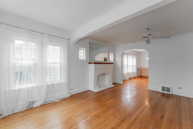 unfurnished living room featuring light wood-type flooring, ceiling fan, and crown molding