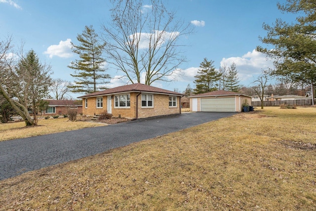 single story home featuring brick siding, a detached garage, a front lawn, and an outdoor structure