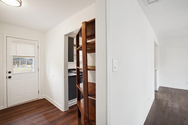 entryway featuring baseboards and dark wood-type flooring