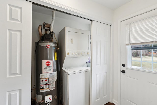 laundry room with laundry area, gas water heater, and stacked washer / drying machine