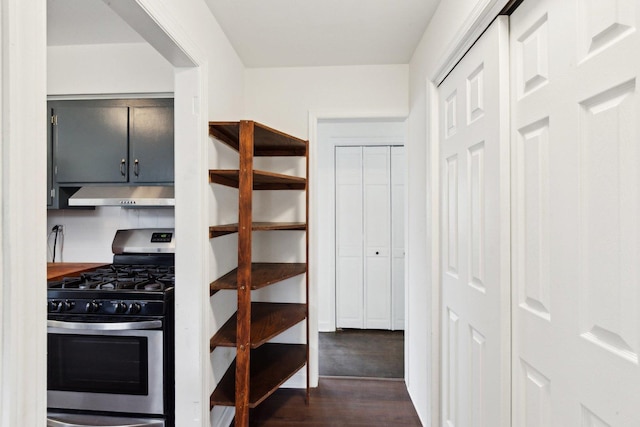 kitchen featuring dark wood-style floors, gray cabinetry, stainless steel range with gas cooktop, and under cabinet range hood