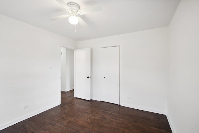 unfurnished bedroom featuring ceiling fan, a closet, wood finished floors, and baseboards