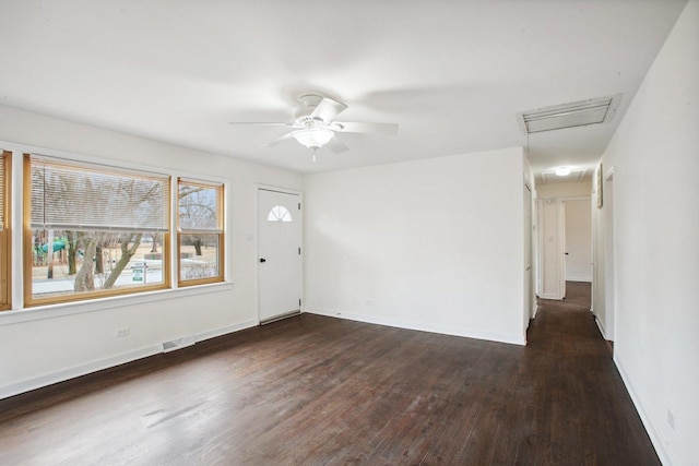 empty room with baseboards, visible vents, ceiling fan, and dark wood-type flooring