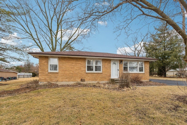 ranch-style home featuring brick siding and a front lawn