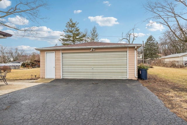 detached garage featuring fence