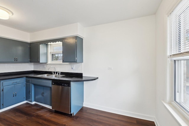 kitchen with a sink, baseboards, dishwasher, dark countertops, and dark wood finished floors