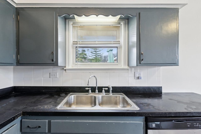 kitchen featuring gray cabinets, a sink, backsplash, and stainless steel dishwasher