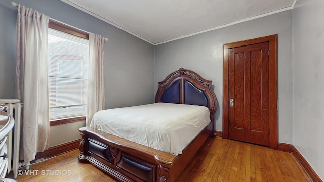 bedroom featuring light hardwood / wood-style flooring and ornamental molding