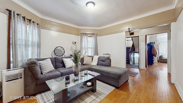 living room featuring ornamental molding, a barn door, and hardwood / wood-style floors