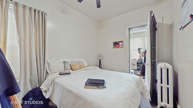 bedroom featuring ceiling fan, radiator heating unit, and vaulted ceiling