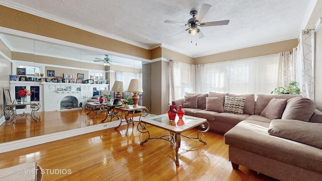 living room featuring a brick fireplace, crown molding, wood-type flooring, and a textured ceiling