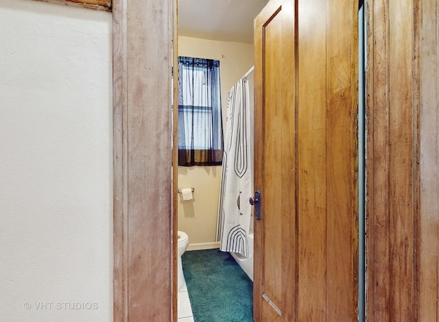 bathroom featuring toilet and shower / bath combo with shower curtain