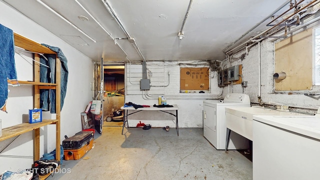 basement featuring electric panel and washer and clothes dryer