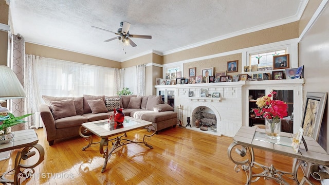 living room featuring hardwood / wood-style floors, a textured ceiling, a wealth of natural light, and a brick fireplace