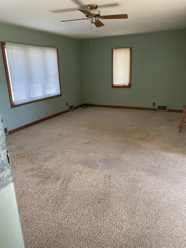 carpeted empty room featuring ceiling fan