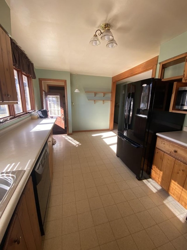 kitchen featuring hanging light fixtures, black appliances, and sink