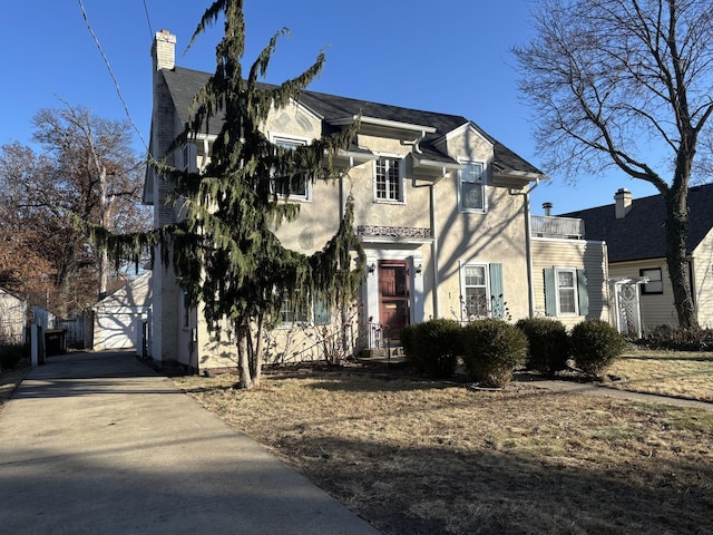 view of front of house with a garage and an outbuilding