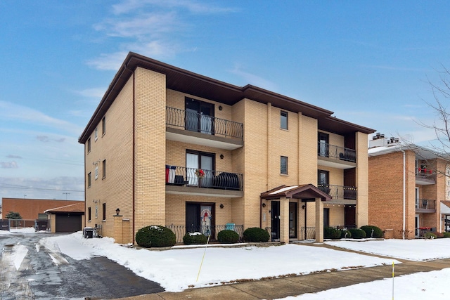 snow covered property featuring central AC unit