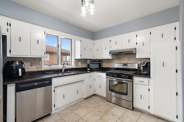 kitchen featuring appliances with stainless steel finishes, sink, white cabinets, backsplash, and light tile patterned floors