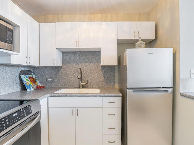 kitchen featuring sink, white cabinets, tasteful backsplash, and stainless steel appliances