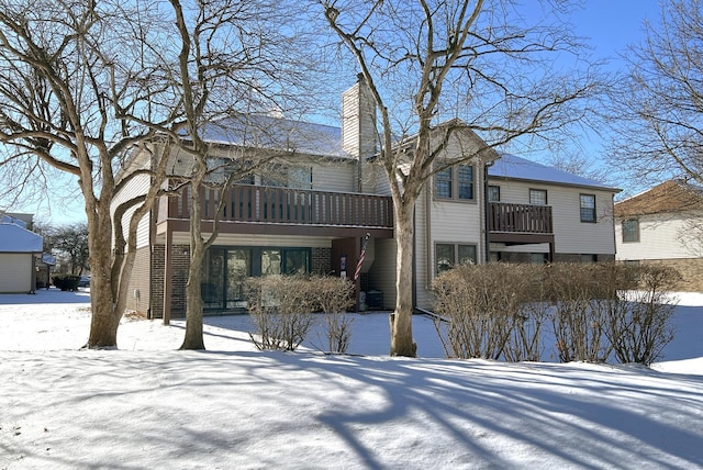 view of snow covered back of property