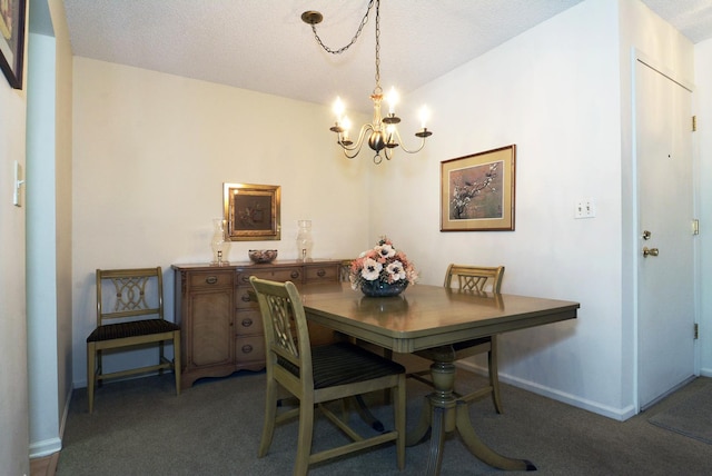 dining area featuring a notable chandelier, a textured ceiling, and dark colored carpet