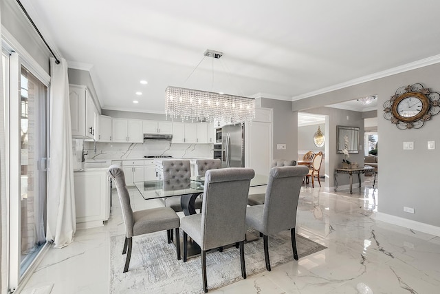 dining room with crown molding, sink, and a chandelier